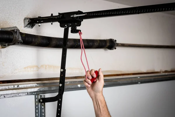 Homem puxa liberação rápida vermelho para um abridor de porta de garagem — Fotografia de Stock