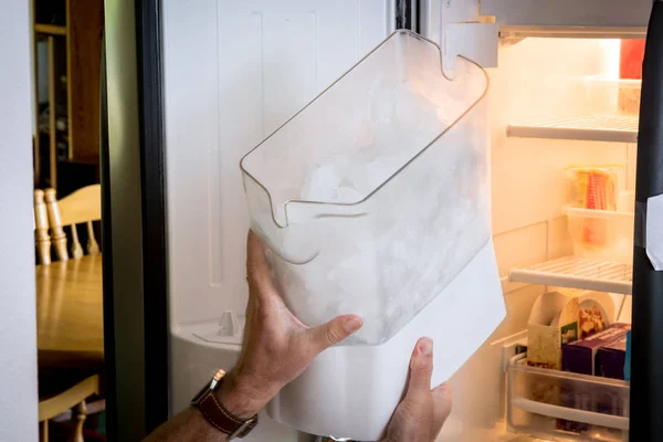 El hombre demuestra cómo eliminar un fabricante de cubos de hielo — Foto de Stock