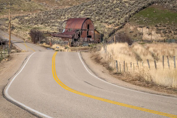 Rural road and rusted old barn in the country — Stock Photo, Image