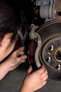 Young girl replaces brakes on a truck