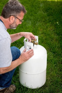 Adam beyaz bir propan tankı ile çalışıyor 