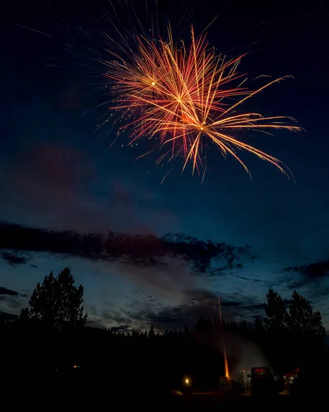 Uniek uitzicht van achter een vuurwerk show in de blauwe hemel van vroeg — Stockfoto