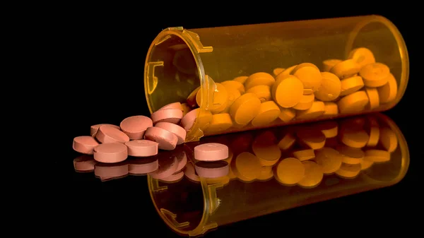 Muchas píldoras de medicamentos que se derraman de un frasco —  Fotos de Stock