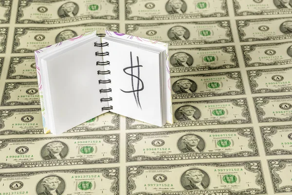 Pad of paper with a money sign on dollar dills — Stock Photo, Image