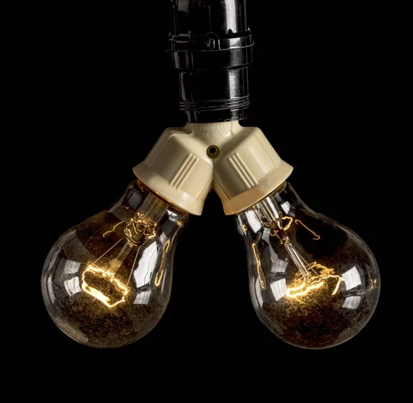 Due lampadine ad incandescenza che vengono accese — Foto Stock