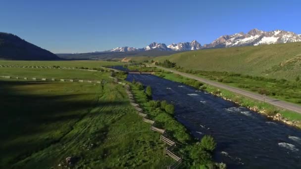 农民土地上的牧场在河流和壮丽的山脉前用栅栏排列 — 图库视频影像