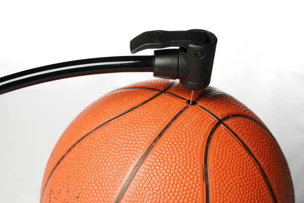 Vzduchová pumpa plní oranžový basketbal — Stock fotografie