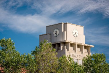 Bulutlar ve ağaçlar ile Kütüphane saat kuleleri