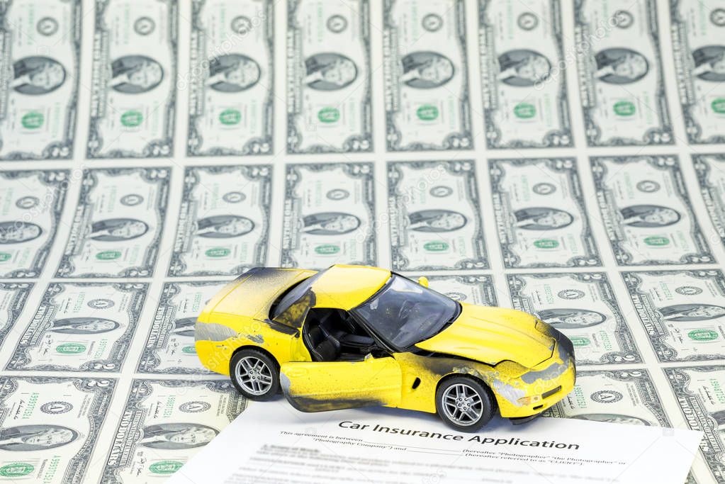 Sheet of two dollar bills and car with insurance form