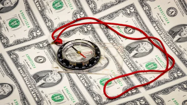 Classic compas with a red string on green dollars — Stock Photo, Image