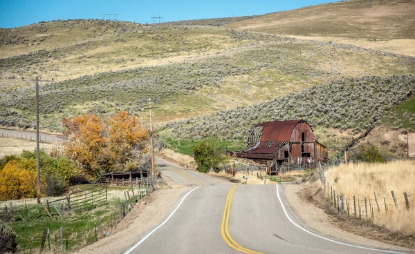 标志性的谷仓在爱达荷州与秋天的树木和乡村道路 — 图库照片