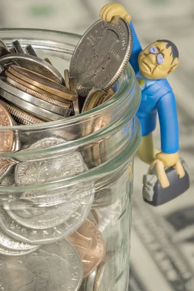 Toy man hangs on to a quarter — Stock Photo, Image