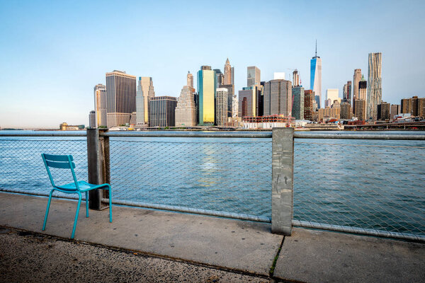 Голубой стул и нью-йоркский горизонт из Бруклина
