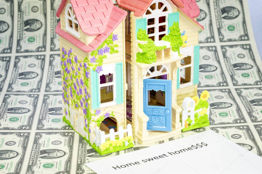 Sheet of us currency and a dollhouse