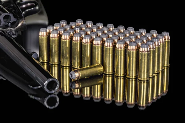 Muitas balas de latão e cobre com uma pistola — Fotografia de Stock