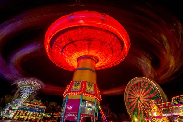 Tour de spinning à la foire à la fin de la nuit illuminé avec lig — Photo
