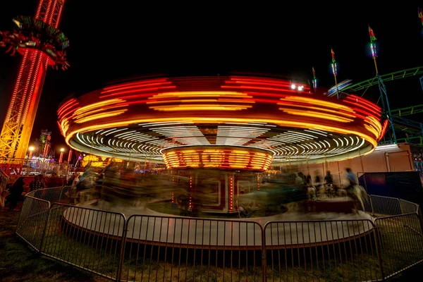 Merry-go-round dans le flou de mouvement de nuit comme la traînée de lumière dans un cir — Photo