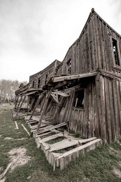 Old wood building crumbles from time and weather in a western to