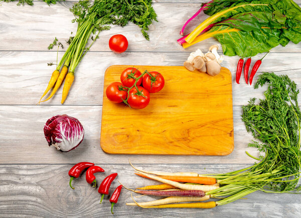 Ассортимент различных видов овощей, окружающих режущее бо
