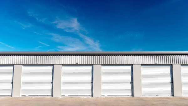 Garagens em uma fazenda local de armazenamento com céu azul e nuvens — Fotografia de Stock