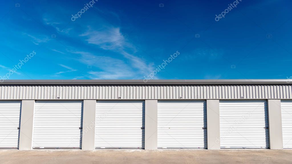 Garages at a local storage unit farm with blue sky and clouds