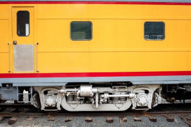 Tam boy tren vagonu raylarda. Sarı ve kırmızı boyalı.