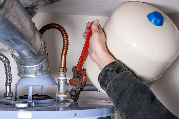 Tightening a pipe on a water heater — Stock Photo, Image