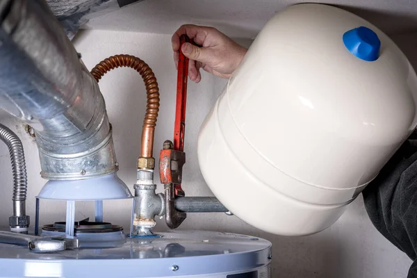 Plumbers does maintenance on a hot water heater — ストック写真