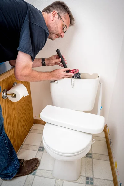 A vízvezeték-szerelő kicseréli az alkatrészeket egy régi WC-ben — Stock Fotó