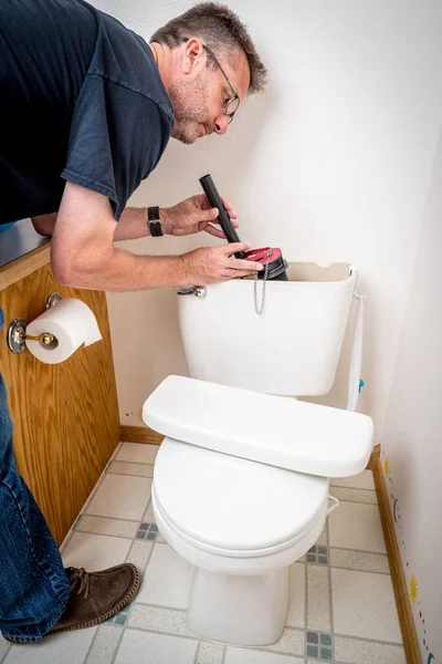 Idraulico sostituisce parti in un vecchio bagno — Foto Stock