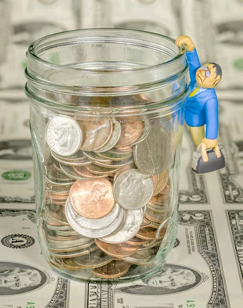 Man with briefcase hang from jar of coins — Stock Photo, Image