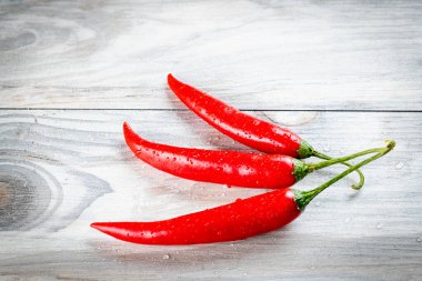 Üzerinde su damlacıkları olan üç lezzetli kırmızı biber.