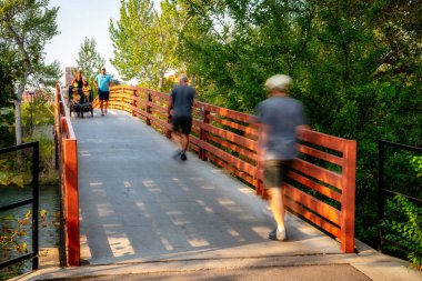 Birçok insan vahşi bir nehri geçerken adımlarını atıyor.