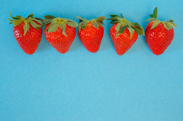 Tasty fresh strawberries on a blue background