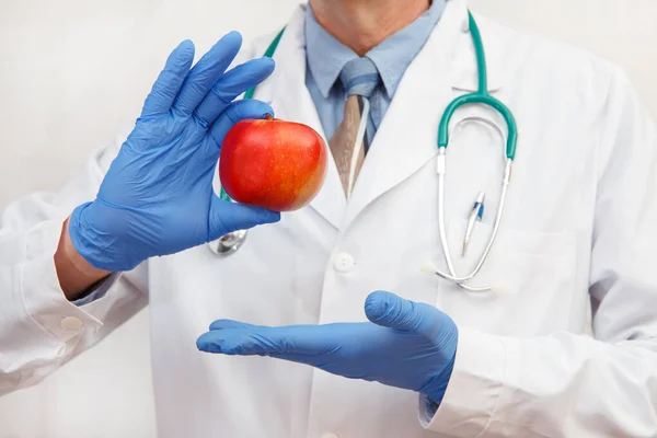 保護手袋の医師は 健康的な食事やライフスタイルや適切な栄養の概念としてリンゴを示しています — ストック写真