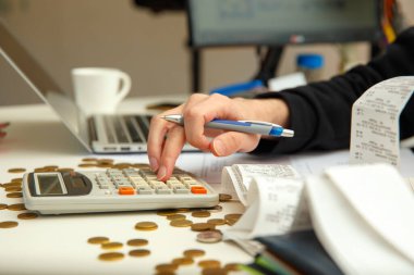 Genç bir adam kazanç ve vergileri sayar. Genç adam mali belgeleri inceliyor.