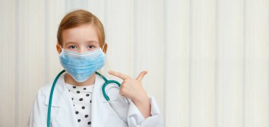 Doktor önlüğü ve maskesi takan küçük bir kız herkesin koruyucu maske takması gerektiğini gösteriyor. Yazıtlar için boşluk