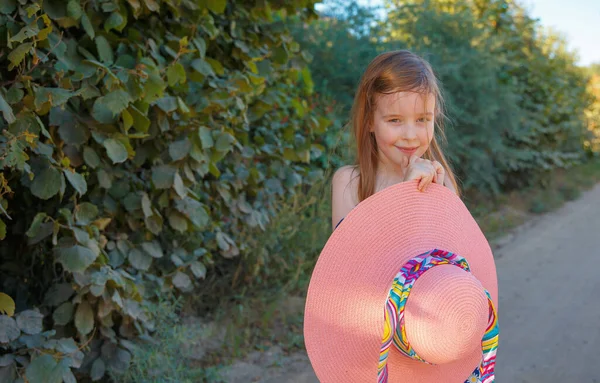 Das Mädchen Hält Einen Großen Rosafarbenen Hut Den Händen Und — Stockfoto