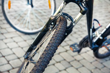 Bisiklet tekerleği kapalıyken. Şehir parkında bir bisiklet park edilmiş..