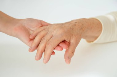 Ellere yardım etmek, yaşlı kavramına özen göstermek. Doktorun eli bir kadının elini tutar.