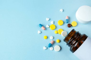 Mavi arka planda farklı renklerde ilaç yığını. Sağlık ve Tıp Konsepti.