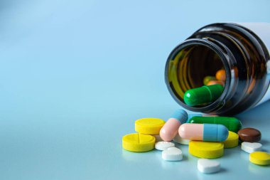 Mavi arka planda farklı renklerde ilaç yığını. Sağlık ve Tıp Konsepti.