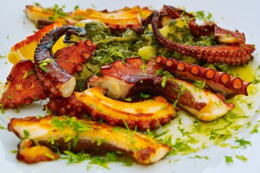 Beyaz tabakta kızarmış sebzeli ahtapot salatası. Lezzetli, sağlıklı geleneksel deniz ürünleri..