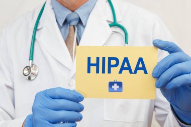 Eldivenli bir erkek doktorun HIPAA yazısı taşıdığı 1996 Sağlık Sigortası Taşınabilirliği ve Güvenilirlik Yasası.