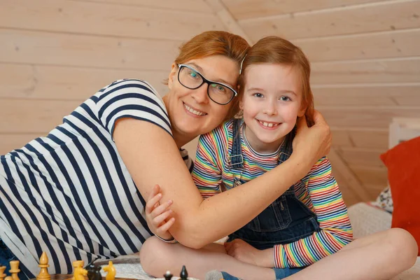 Küçük kız ve annesi gülümsüyor. Bir anne ve kızın portresi.