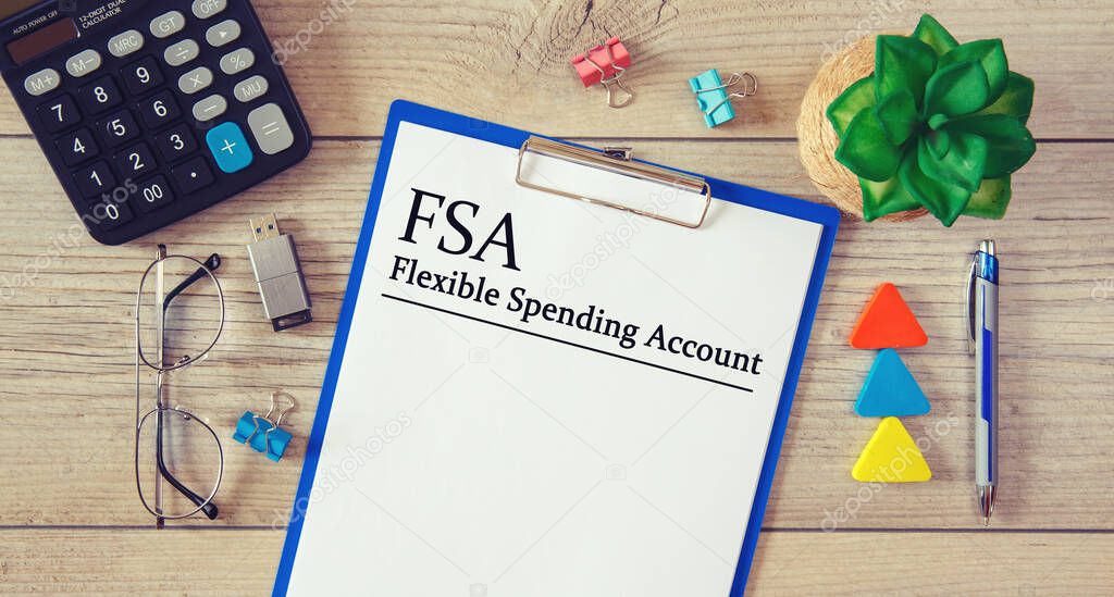 Paper with Flexible Spending Account FSA on the table, calculator and glasses