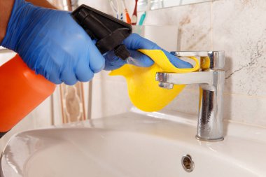 Krom banyo elementlerini kireç pulunu kaldırmak için özel bir araçla temizleme.