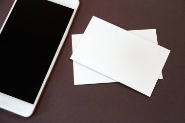 Boş kartvizit ve masadaki siyah akıllı telefon ekranını düzenle