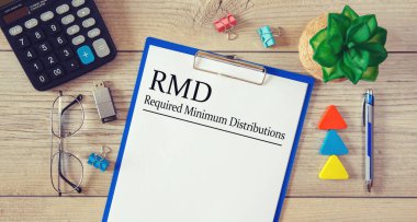 Bir tablo, hesap makinesi ve gözlük üzerinde Gerekli Minimum Dağıtım RMD içeren kağıt