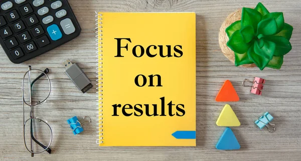 Focus on results is written on a notepad, on an office desk with office accessories.